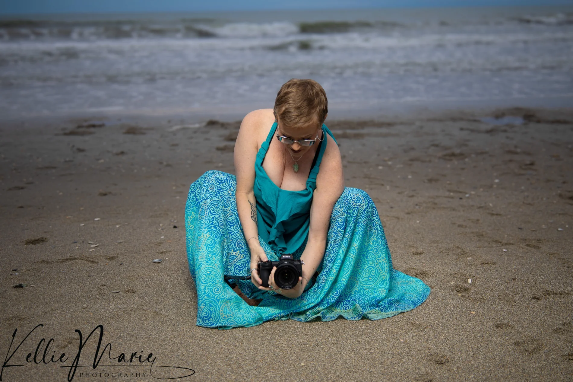 Casey sitting on the beach with her camera