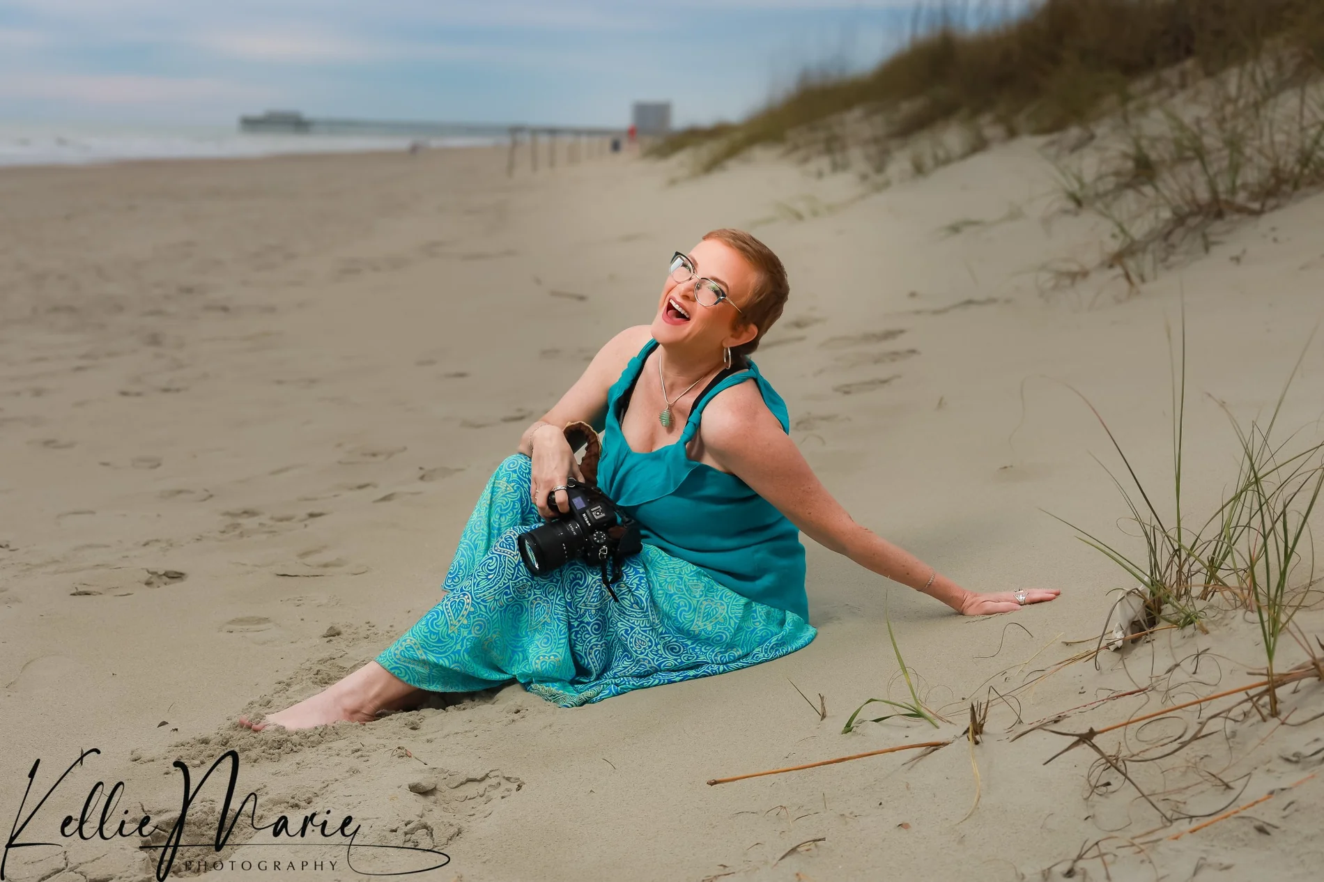 Casey laughing with her camera on the beach
