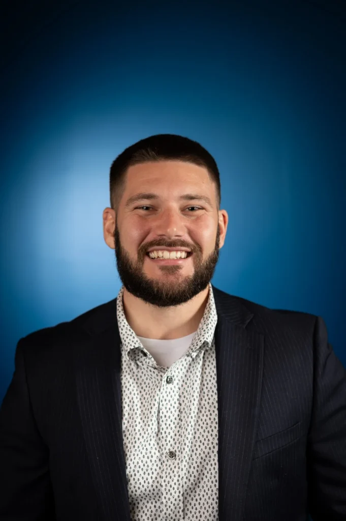 Smiling professional headshot against a blue background