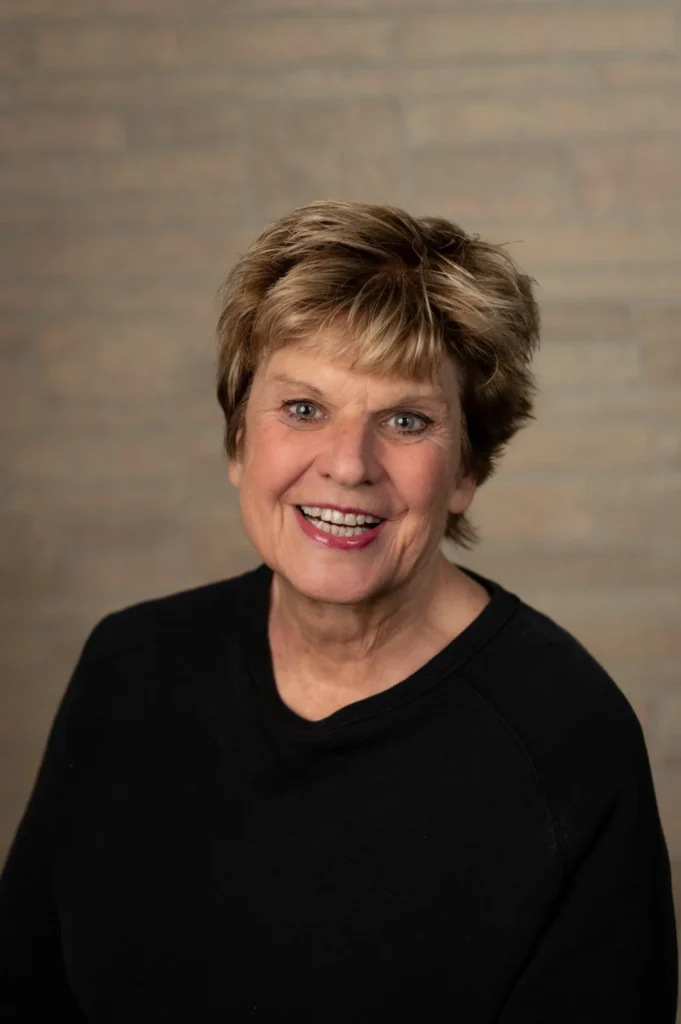 Smiling headshot against a brick backdrop