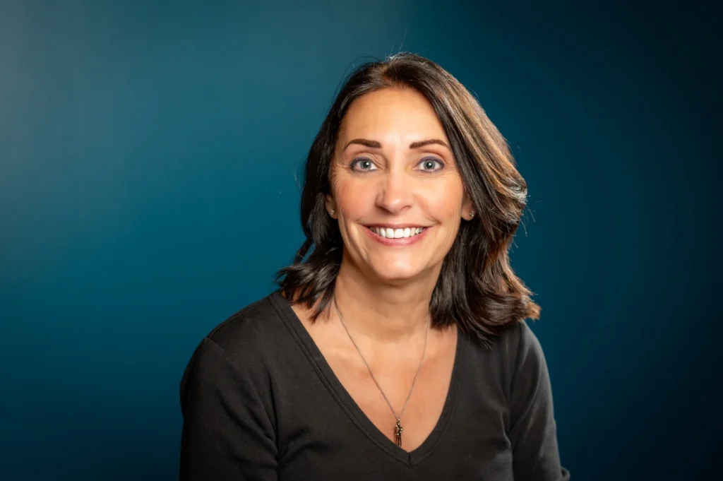 Smiling headshot in black against a blue background