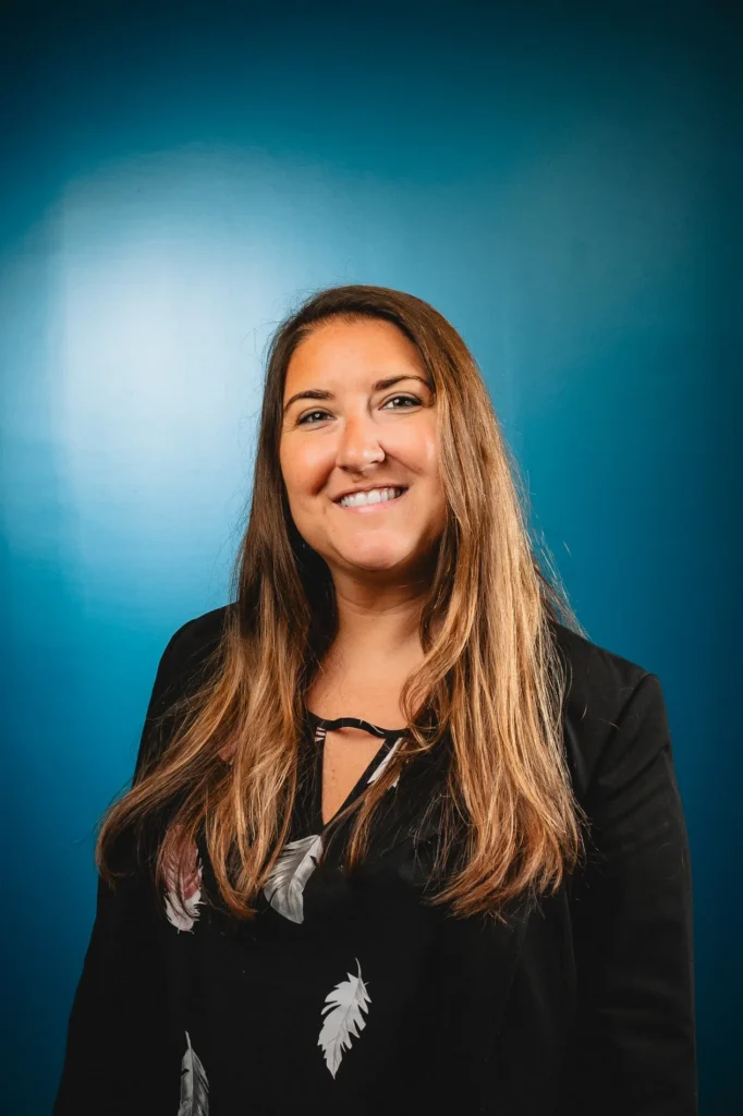 Smiling studio headshot in black