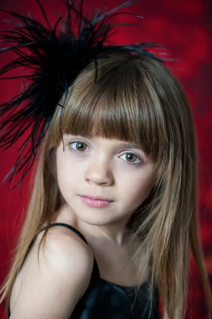 Studio portrait with a dark feathered headpiece