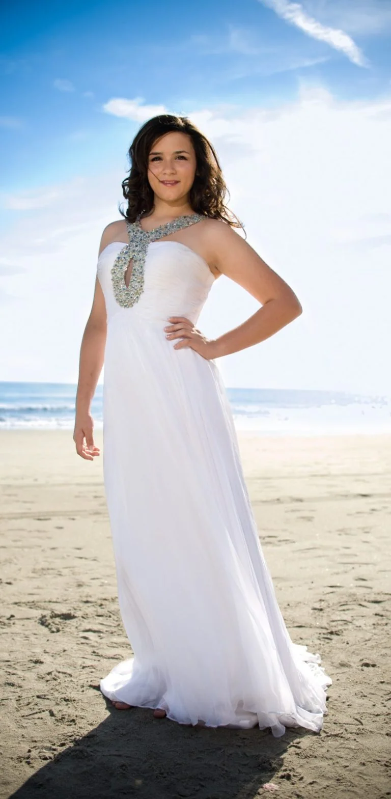 Senior portrait in a white gown on the beach