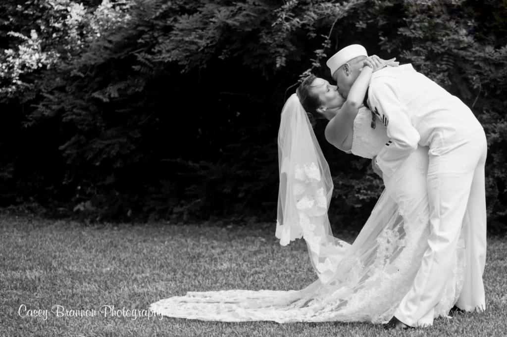 Newlyweds sharing a kiss in a monochrome outdoor portrait
