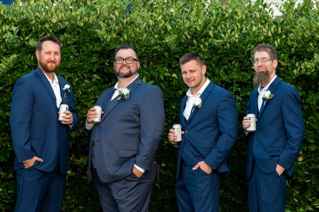 Groom and three groomsmen in blue suits outdoors