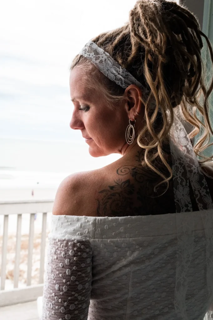 Bride looking toward the ocean from a balcony