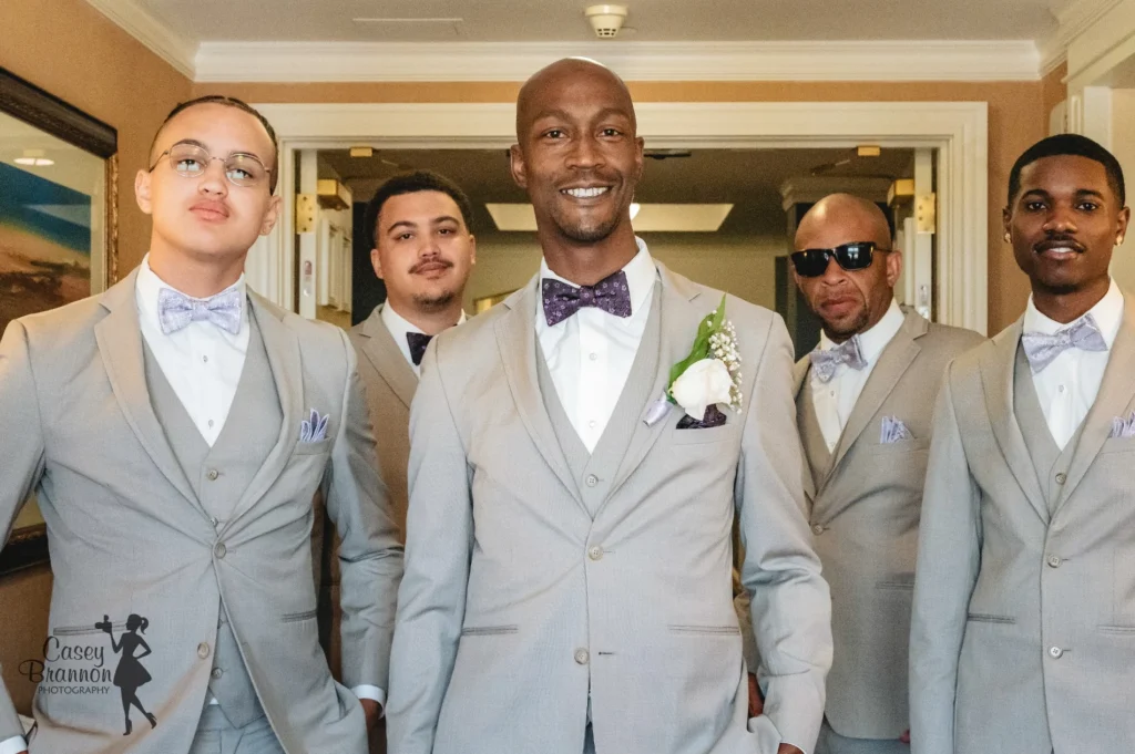 Groom and groomsmen dressed in pale suits