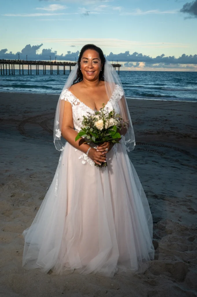 Bride holding a bouquet beside the ocean