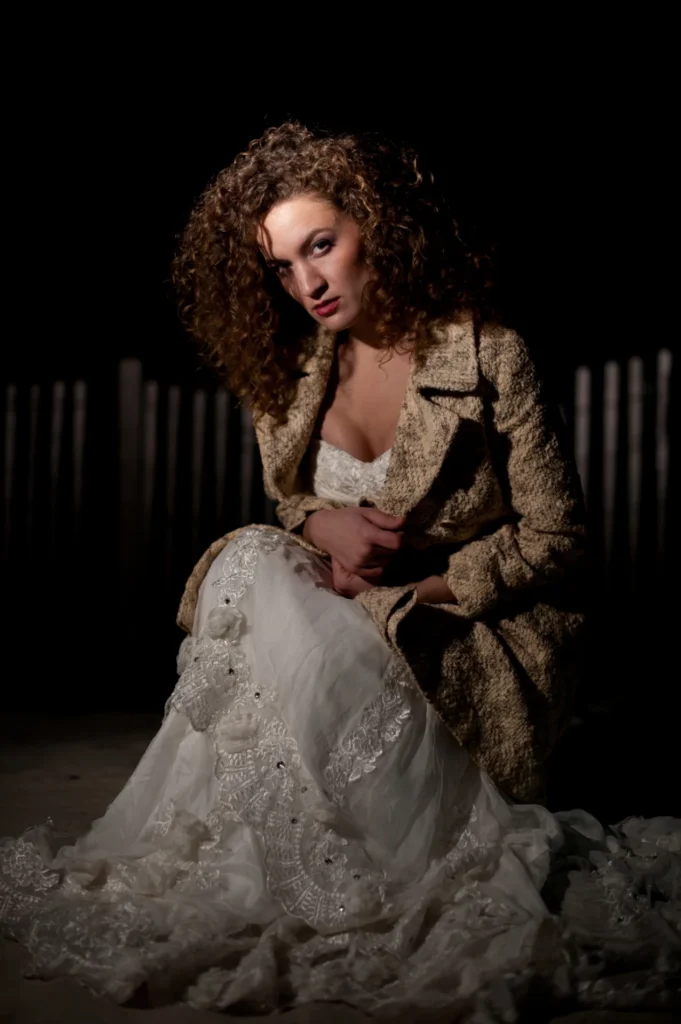 Bride seated in dramatic light against a dark background