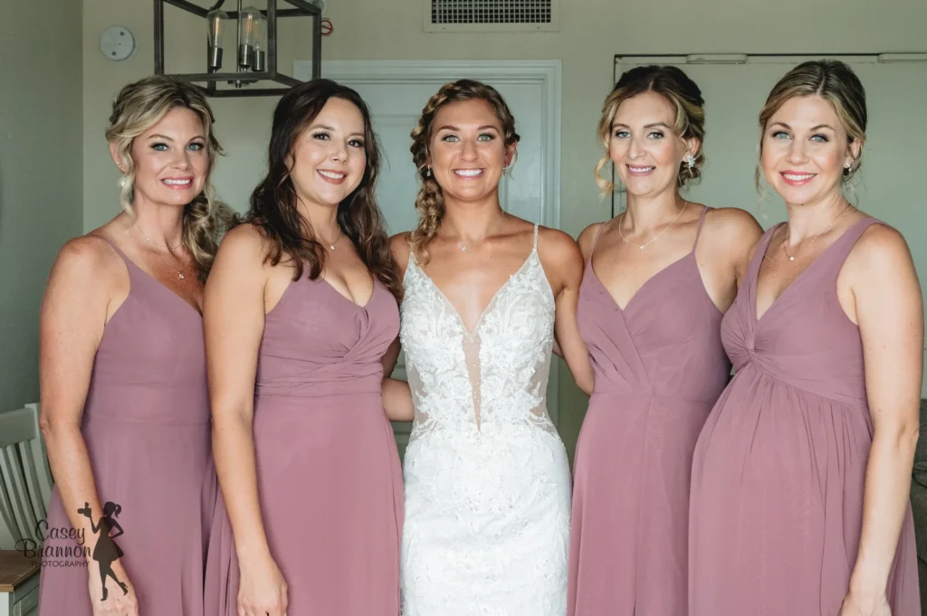 Bride surrounded by bridesmaids in mauve dresses